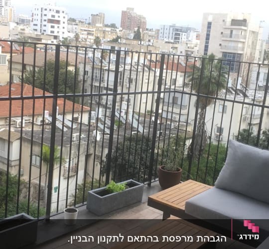 מעקה ברזל במרפסת עם נוף עירוני